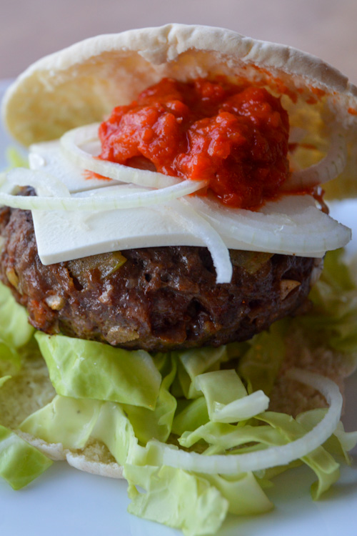 Close up of our Balkan burger with ajvar and white cheese on a pita