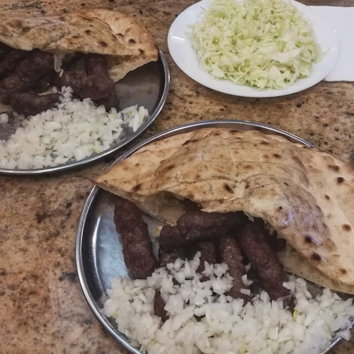 Two plates of cevapi plus one plate of cabbage in Sarajevo