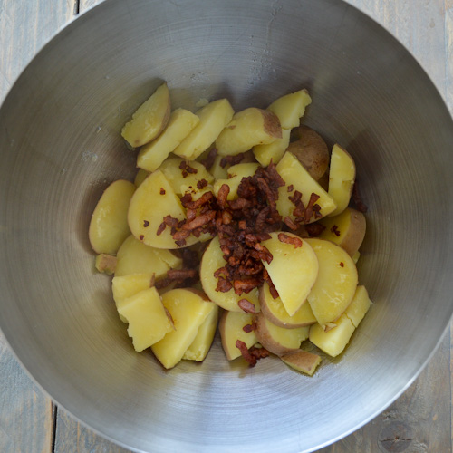 Boiled potatoes with bacon lardons in a bowl