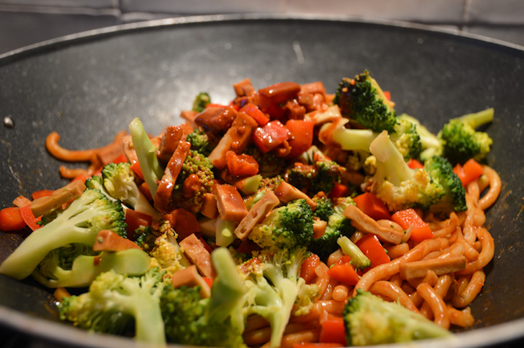 Veggie udon noodles cooking in a wok