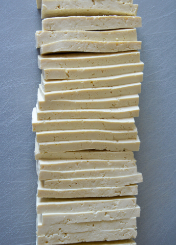 A stack of sliced tofu which will be turned into delicious Asian baked tofu