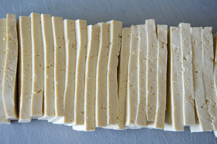 Unmarinated tofu slices on a baking sheet - ready to be turned into Asian baked tofu