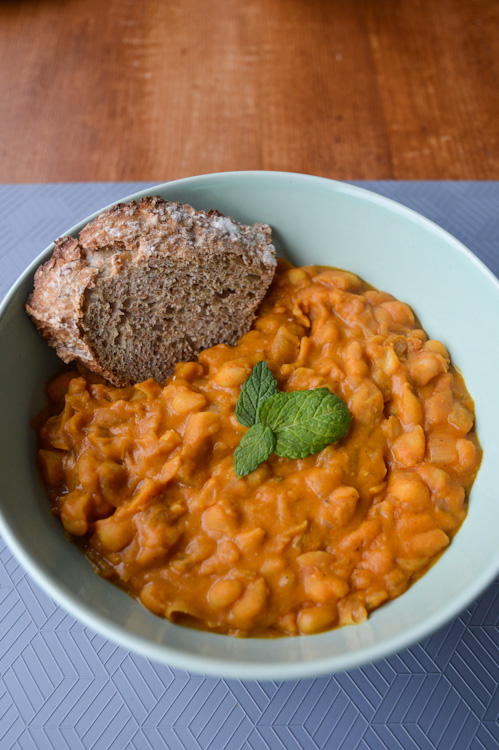 Tavce gravce inspired Macedonian beans in a bowl with a piece of crusty bread