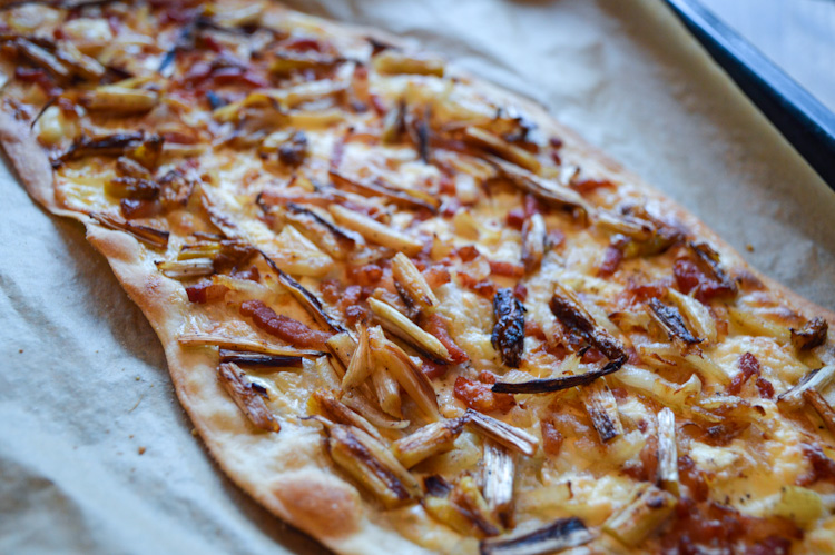 Flammkuchen with white asparagus on a baking sheet