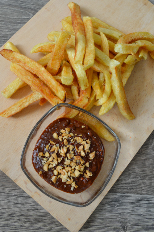 Pindasaus (Dutch peanut sauce) with french fries on a wooden board