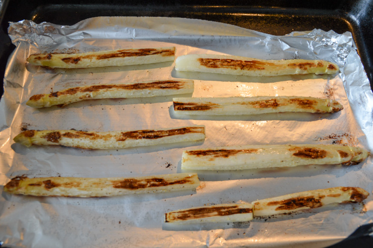 Roasted white asparagus - halfway cooked on a baking sheet