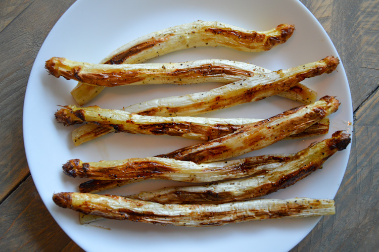 8 roasted white asparagus on a white plate