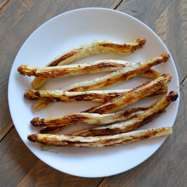 Roasted white asparagus spears on a white plate