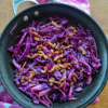 Sautéed red cabbage with crispy bacon lardons on a pink and white towel