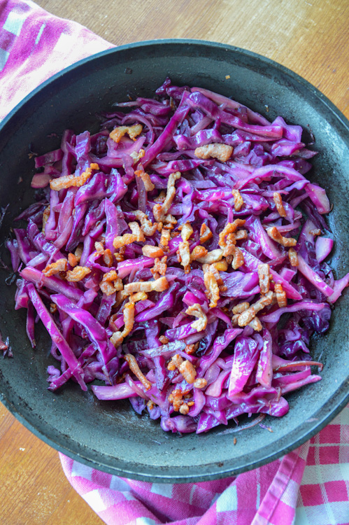 Sautéed red cabbage with bacon on a pink and white towel