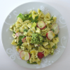 A plate of pasta salad with radish greens pesto on a white table