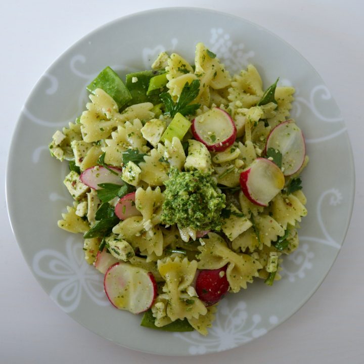 Plate of radish greens pesto pasta salad with radishes and parsley