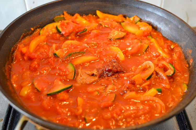 Vegetables stewing in tomato sauce with dollops of miso paste and sambal on top