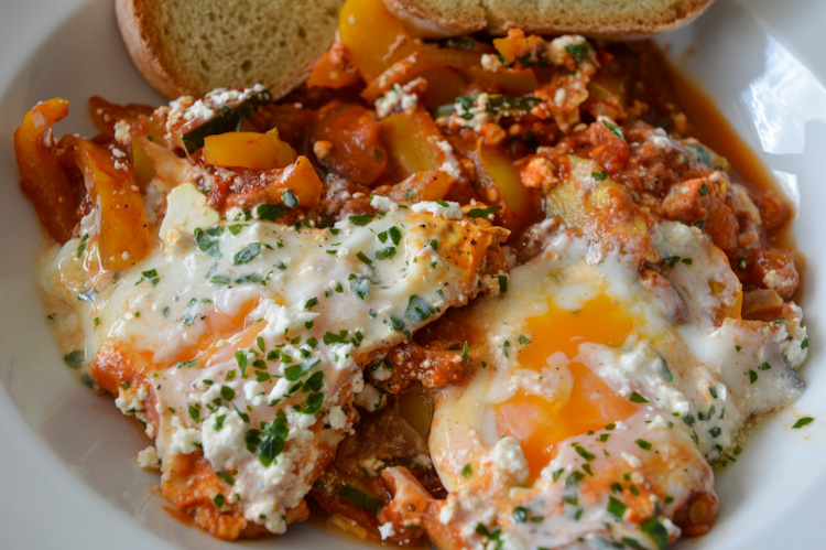 A close up of a bowl with shakshuka with slightly runny eggs