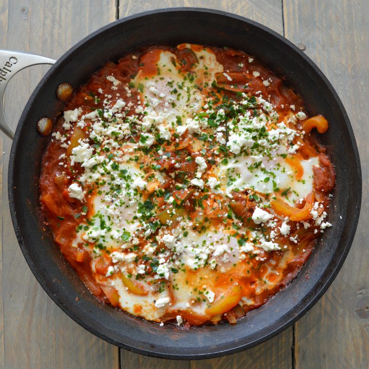 Skillet with shakshuka for two, sprinkled with feta an parsley