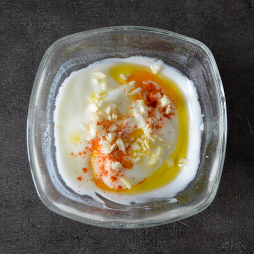 Bowl of yogurt sauce with olive oil, lemon juice, garlic, and smoked paprika