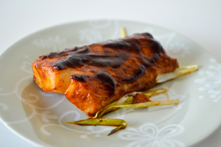 A piece of baked cod cooked in a miso ginger marinade on a small plate