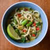 Blue bowl of curry udon soup with a lime wedge