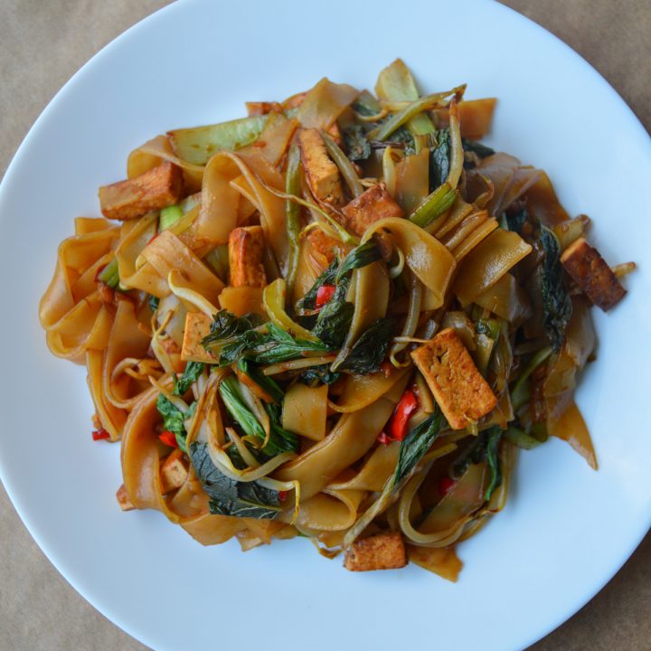 White plate with a pile of vegetarian drunken noodles