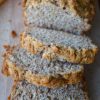 Sliced loaf of whole wheat beer bread on a wood board