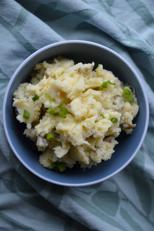 Miso mashed potatoes in a blue bowl on a green fabric background