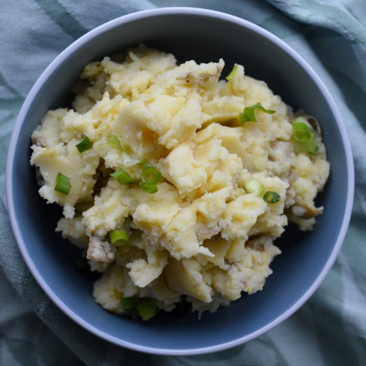 Miso mashed potatoes with scallions in a blue bowl