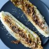 Roasted napa cabbage on a black plate on a blue placemat