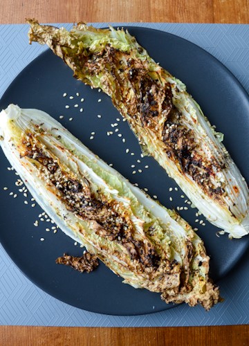 Roasted napa cabbage on a black plate on a blue placemat