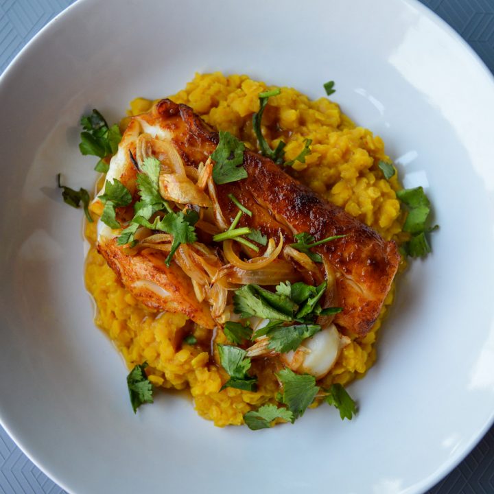 Bowl of red curry lentils with red curry cod atop it