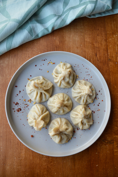 7 khinkali - Georgian soup dumplings - on a plate on a wood table