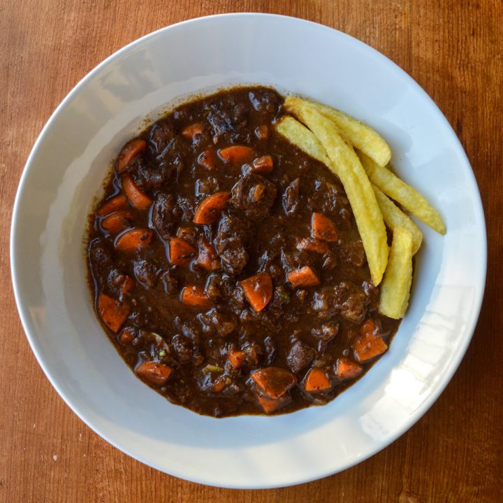 Bowl of stoovflees Flemish beef stew with a few fries