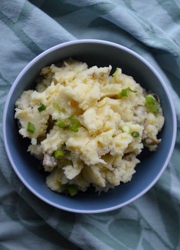 Small blue bowl of miso mashed potatoes on a green fabric background