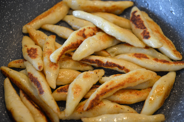 Lightly browned small potato dumplings in a pan