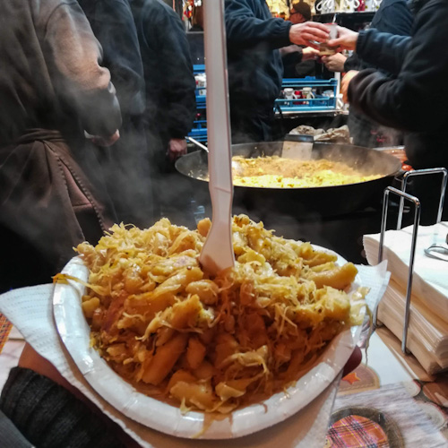 Traditional Schupfnudeln (one of our favorite Christmas Market foods) with sauerkraut and speck, eaten in Stuttgart, Germany