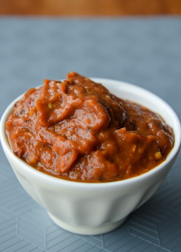 Small white bowl holding a nice amount of red pepper, eggplant spread (aka zacusca)