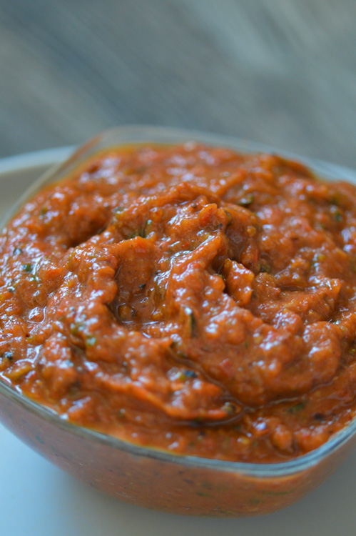 Close up of ajvar, a roasted red pepper and zucchini spread, in a glass dish