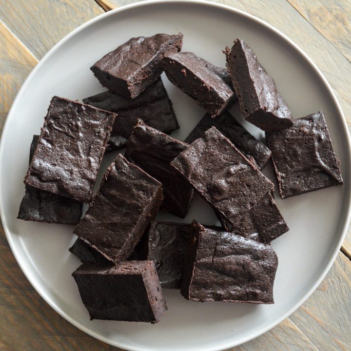 Pile of bourbon maple brownies on a beige plate