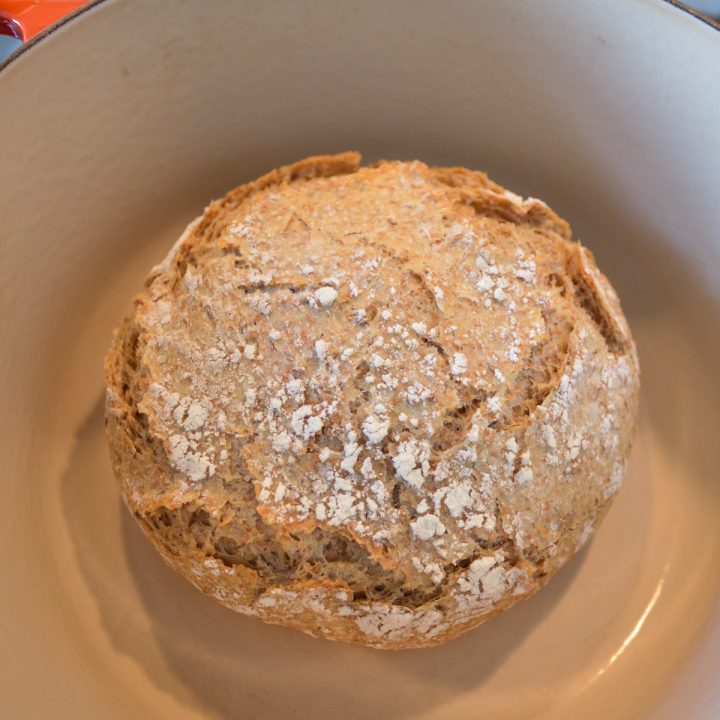 A loaf of no-knead bread in a Dutch oven