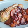 A plate with pork tenderloin and plum sauce