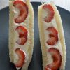 The strawberry sando (Japanese fruit sandwiches) - two pieces standing upright on a black plate